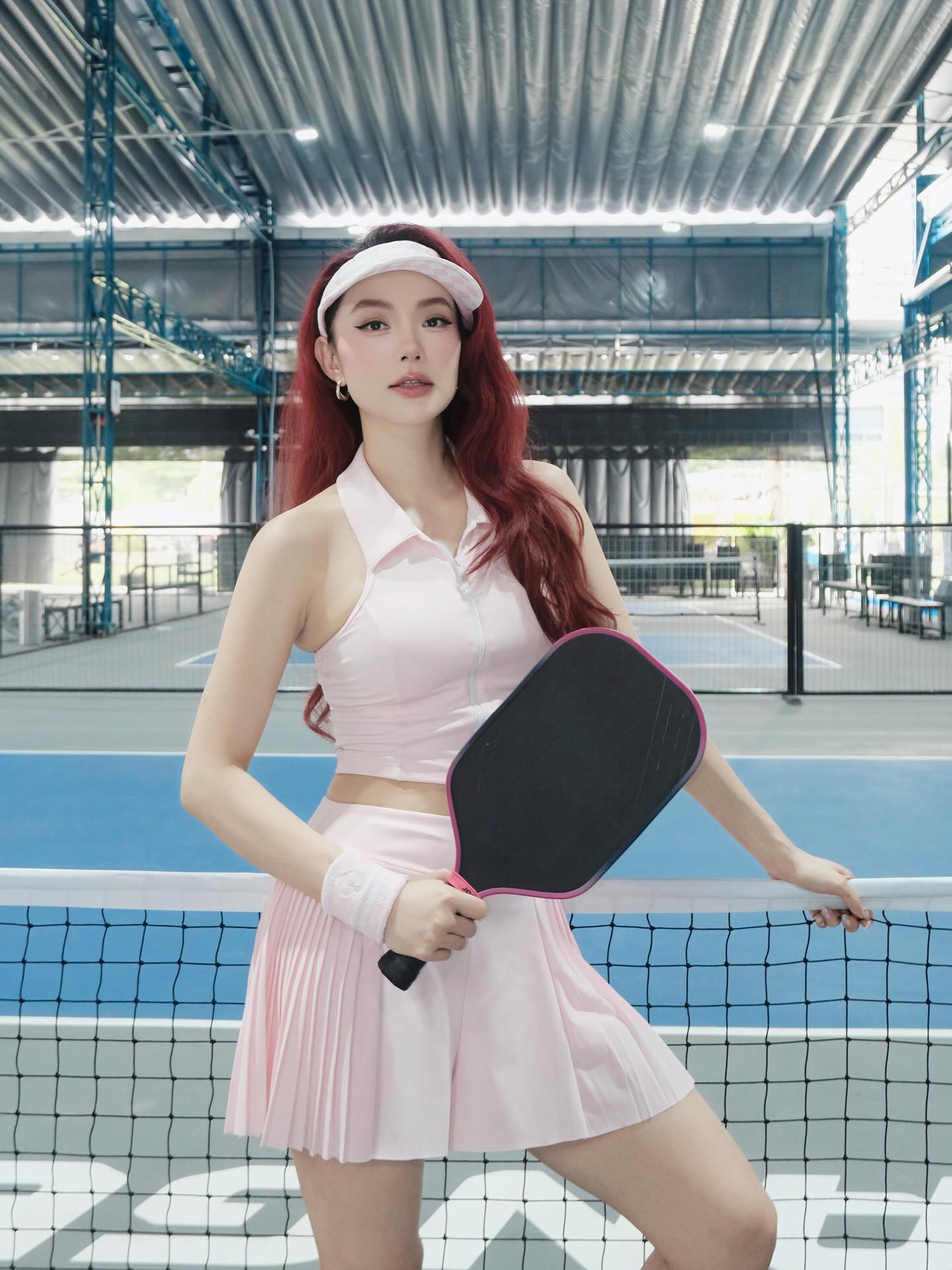 Minh Hằng mặc váy tennis đen trên sân pickleball