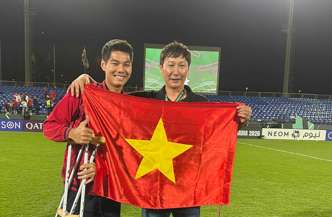 HLV Kim Sang-sik cùng đội trưởng Khuất Văn Khang hỗ trợ trung vệ Hiểu Minh tại sân bay