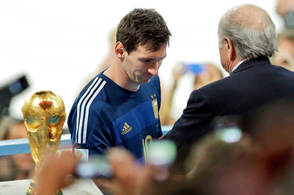 Messi cầm Golden Ball với ánh mắt vô hồn.