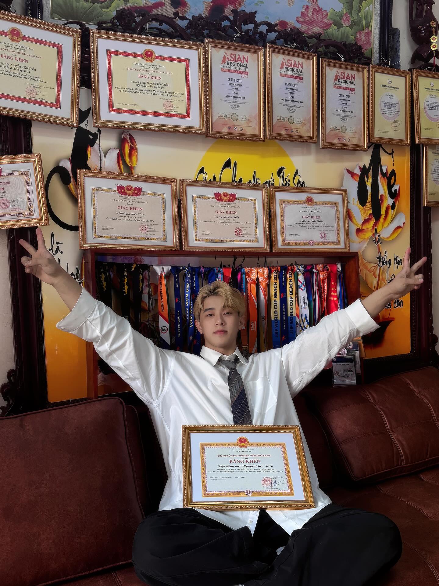 Vận động viên Nguyễn Tiến Triển bên huy chương và cúp danh giá